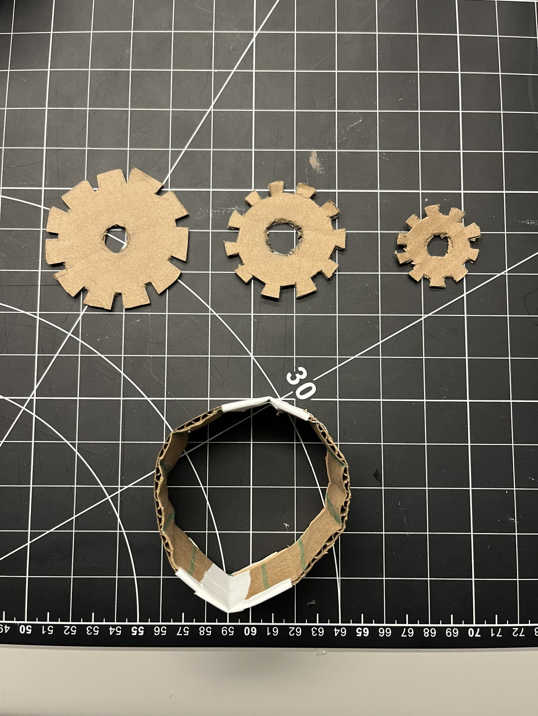 After seeing the gears very broadly, we decided to take it to the next level to actually make the cardboard look like actual gears and as well as add a container around it that was in the shape of a sphere that the gears would go into because in our research one of the tools that we saw is that normally gears would be placed in a sphere and they would help each other work together.